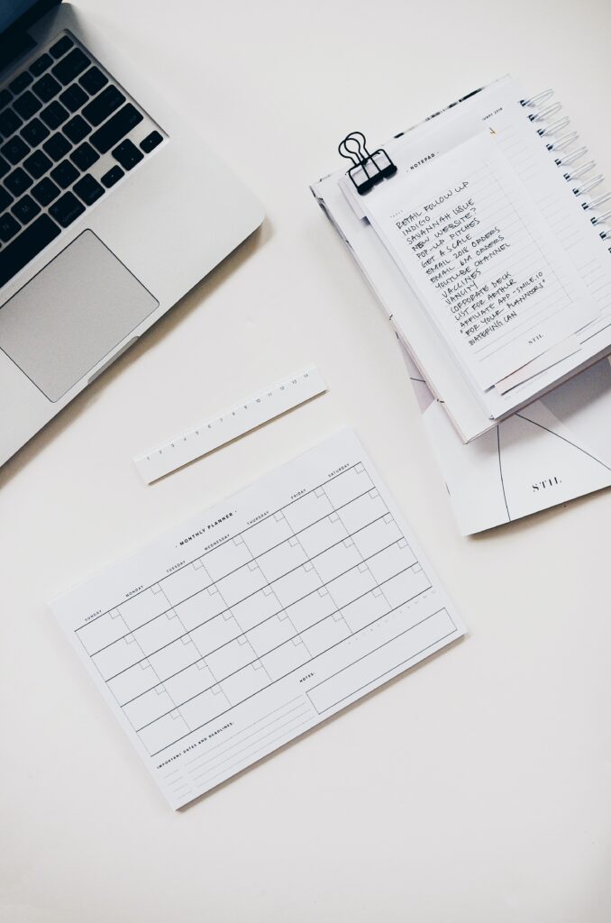 Metrics on a list next to a laptop, ruler, and calendar