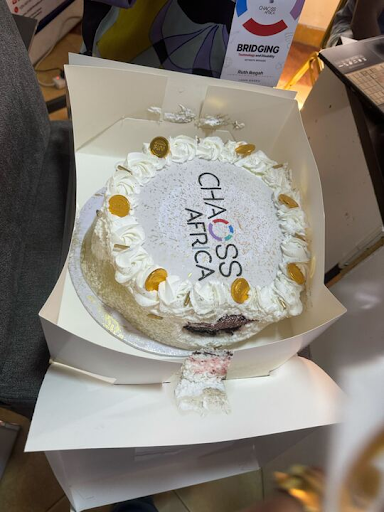 photograph of a white celebration cake with the CHAOSS Africa logo