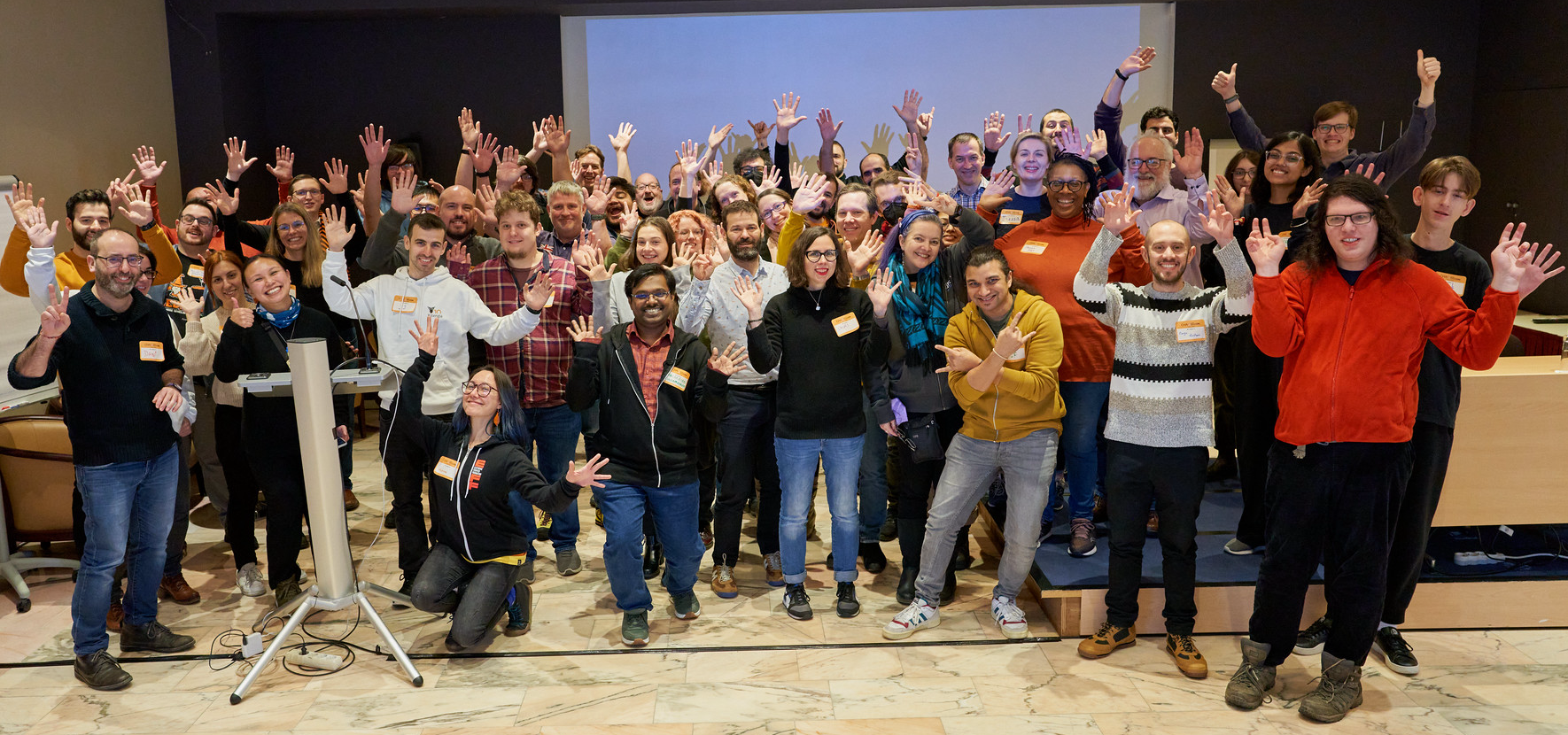 A bunch of CHAOTICs in Brussels at CHAOSScon with their hands in the air for a "funny" group pic.