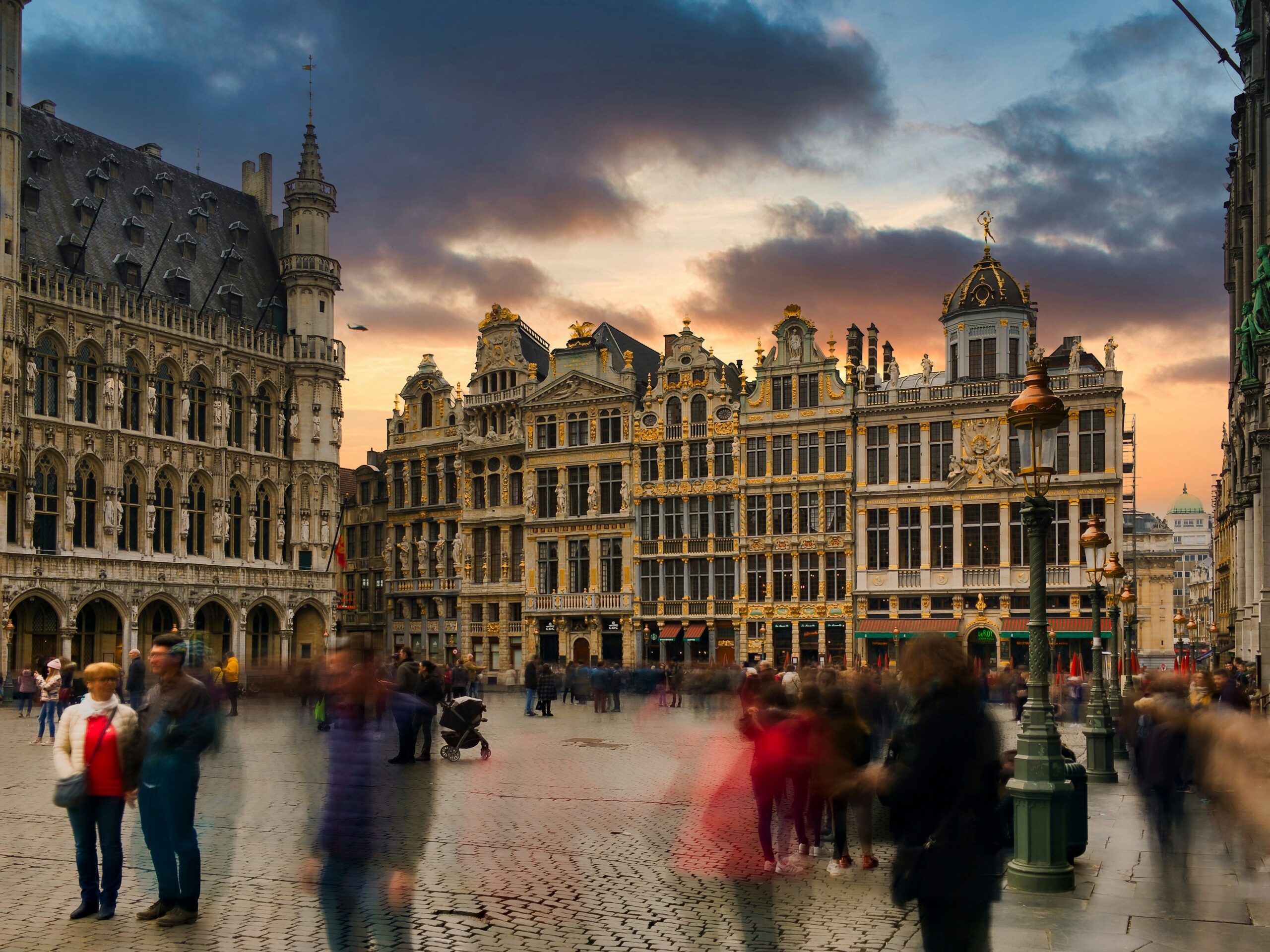 photo of central plaza in brussels with people walking around, blurred to show movement